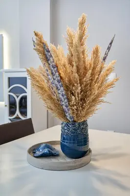 a blue vase with ears of wheat on a table at Old Town Luxury Velvet Apartment in Rhodes Town