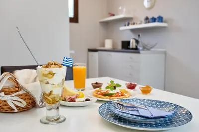 a table with two plates of food and a drink at Old Town Luxury Velvet Apartment in Rhodes Town