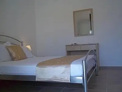 a bedroom with a bed with a dresser and a mirror at 3 Bed Villa In Lardos Village in Lardos