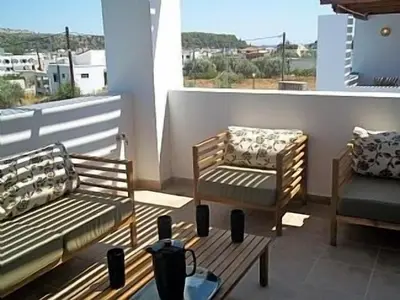 a balcony with two benches and a table and a chair at 3 Bed Villa In Lardos Village in Lardos
