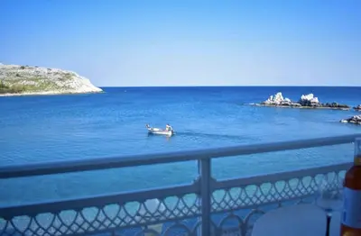 a small boat in the water near a bridge at Haraki Sunset Apartment in Haraki