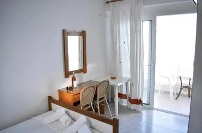 a bedroom with a desk and a mirror and a table at Haraki Sunset Apartment in Haraki