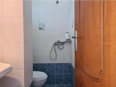 a bathroom with a shower with a toilet and a phone at Haraki Sunset Apartment in Haraki
