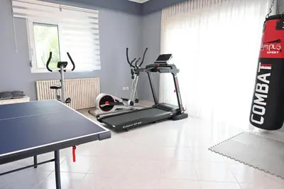 a room with a gym with a treadmill and a table at GianAngelo Holiday Villa in Kremasti