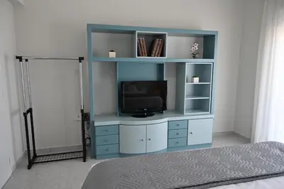 a blue entertainment center with a television in a room at GianAngelo Holiday Villa in Kremasti