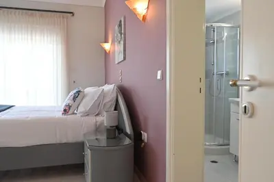 a bedroom with a bed and a glass shower at GianAngelo Holiday Villa in Kremasti