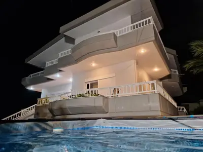 a villa with a swimming pool at night at GianAngelo Holiday Villa in Kremasti