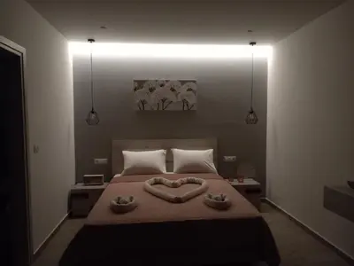 a bedroom with a bed with two heart shaped towels on it at Kolymbia summer holidays in Kolimbia