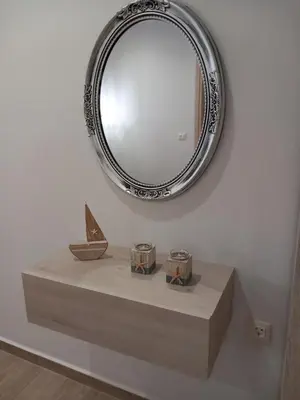 a mirror on a white wall with a table with a mirrorneau at Kolymbia summer holidays in Kolimbia