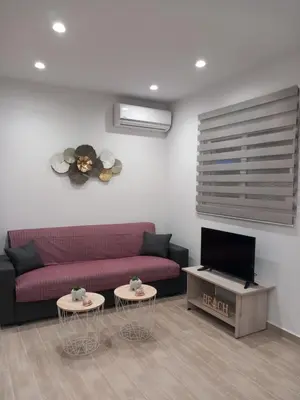 a living room with a red couch and two tables at Kolymbia summer holidays in Kolimbia