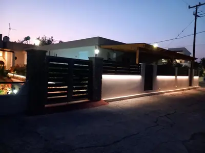 a fence in front of a house at night at Kolymbia summer holidays in Kolimbia
