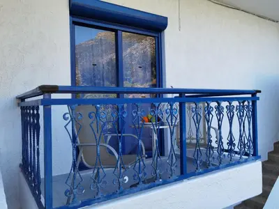a blue railing on a balcony with a window at Marinas Studios in Livadia