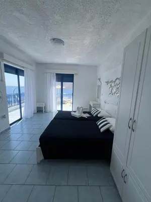 a bedroom with a black bed with a view of the ocean at Marinas Studios in Livadia