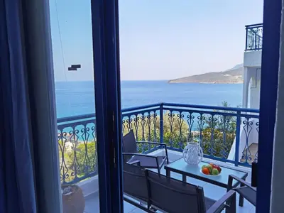 a table and chairs on a balcony with a view of the ocean at Marinas Studios in Livadia
