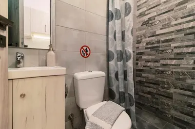 a bathroom with a white toilet and a sink at Fay's Suites in Ialyssos
