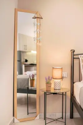 a mirror in a bedroom with a table and a bed at Fay's Suites in Ialyssos