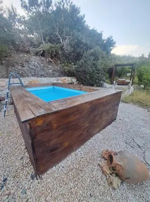 a wooden plunge pool with a wooden deck at Villa Nefeli Rhodes in Archangelos