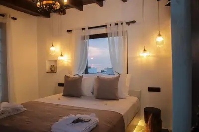 a bedroom with a large bed with a window at Villa Nefeli Rhodes in Archangelos