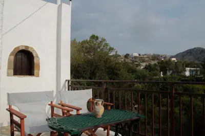 a table and two chairs on a balcony at Villa Nefeli Rhodes in Archangelos