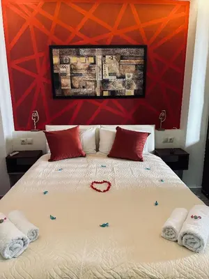 a bedroom with a large bed with red walls at Jz boutique 1 in Rhodes Town