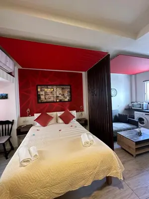 a bedroom with a large bed with a red headboard at Jz boutique 1 in Rhodes Town