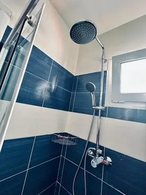 a blue and white shower in a bathroom at Jz boutique 1 in Rhodes Town