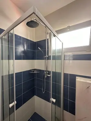 a bathroom with a shower with blue and white tiles at Jz boutique 1 in Rhodes Town