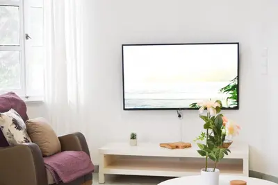 a living room with a tv hanging on the wall at Ixia Manor House in Ixia