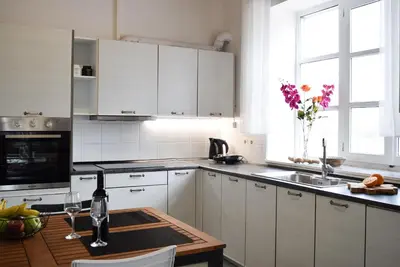 a kitchen with white cabinets and a wooden table at Ixia Manor House in Ixia