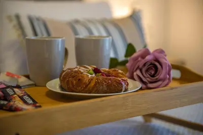 a plate of pastry on a table with a rose at Charavgi Apartment 1 in Kremasti