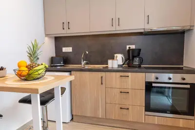 a kitchen with wooden cabinets and a table with a bowl of fruit at Charavgi Apartment 1 in Kremasti