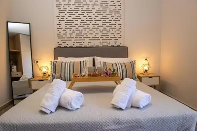 a bedroom with a bed with white pillows and a tray on it at Charavgi Apartment 1 in Kremasti