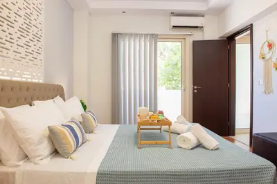 a bedroom with a large bed with pillows and a table at Charavgi apartment 2 in Kremasti