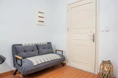 a couch sitting in a room next to a door at Charavgi apartment 2 in Kremasti