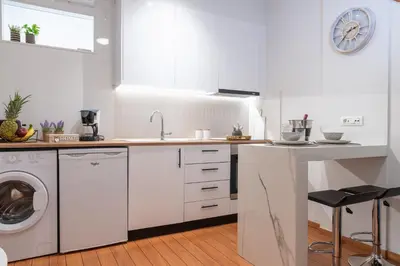a white kitchen with a sink and a washing machine at Charavgi apartment 2 in Kremasti