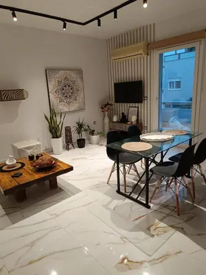 a living room with a glass table and chairs at Seven Palms Central in Rhodes Town