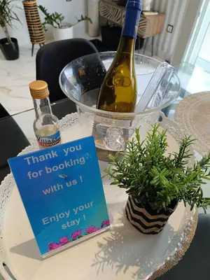 a sign sitting on a table with a bottle of wine at Seven Palms Central in Rhodes Town