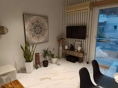 a living room with a television and a table and chairs at Seven Palms Central in Rhodes Town