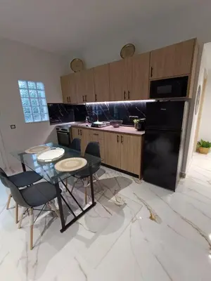 a kitchen with a black refrigerator and a table and chairs at Seven Palms Central in Rhodes Town