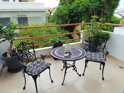a table and chairs on a balcony with plants at Seven Palms Central in Rhodes Town