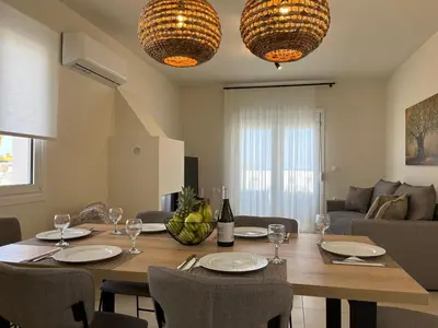 a dining room with a table with plates and wine glasses at Villa Ariadne in Gennadi