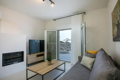 a living room with a couch and a tv at Villa Ariadne in Gennadi