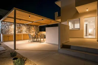 a kitchen and dining area of a house at night at Villa Ariadne in Gennadi