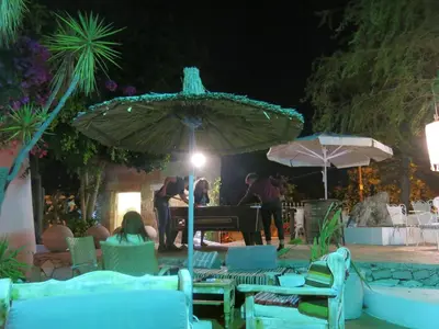 a group of people playing a piano under an umbrella at Gorgona Studios in Faliraki