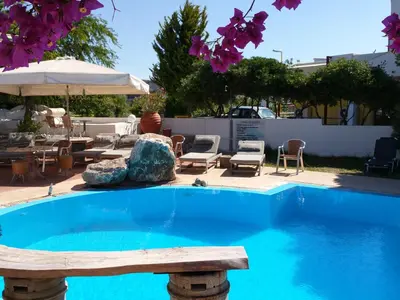 a swimming pool with a bench next to a patio at Gorgona Studios in Faliraki