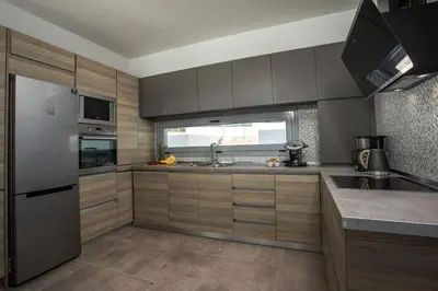 a kitchen with wooden cabinets and a sink and a window at Melilia luxury villa in Gennadi
