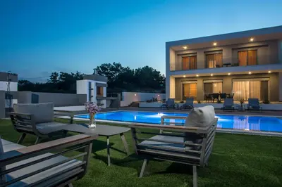 a villa with a swimming pool in front of a house at Melilia luxury villa in Gennadi