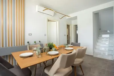 a dining room with a wooden table and chairs at Melilia luxury villa in Gennadi