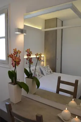 a bedroom with a mirror and a bed with a table at Lindian Pearl in Líndos