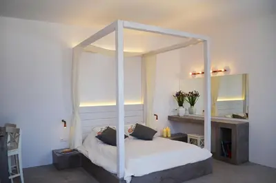 a bedroom with a canopy bed and a mirror at Lindian Pearl in Líndos